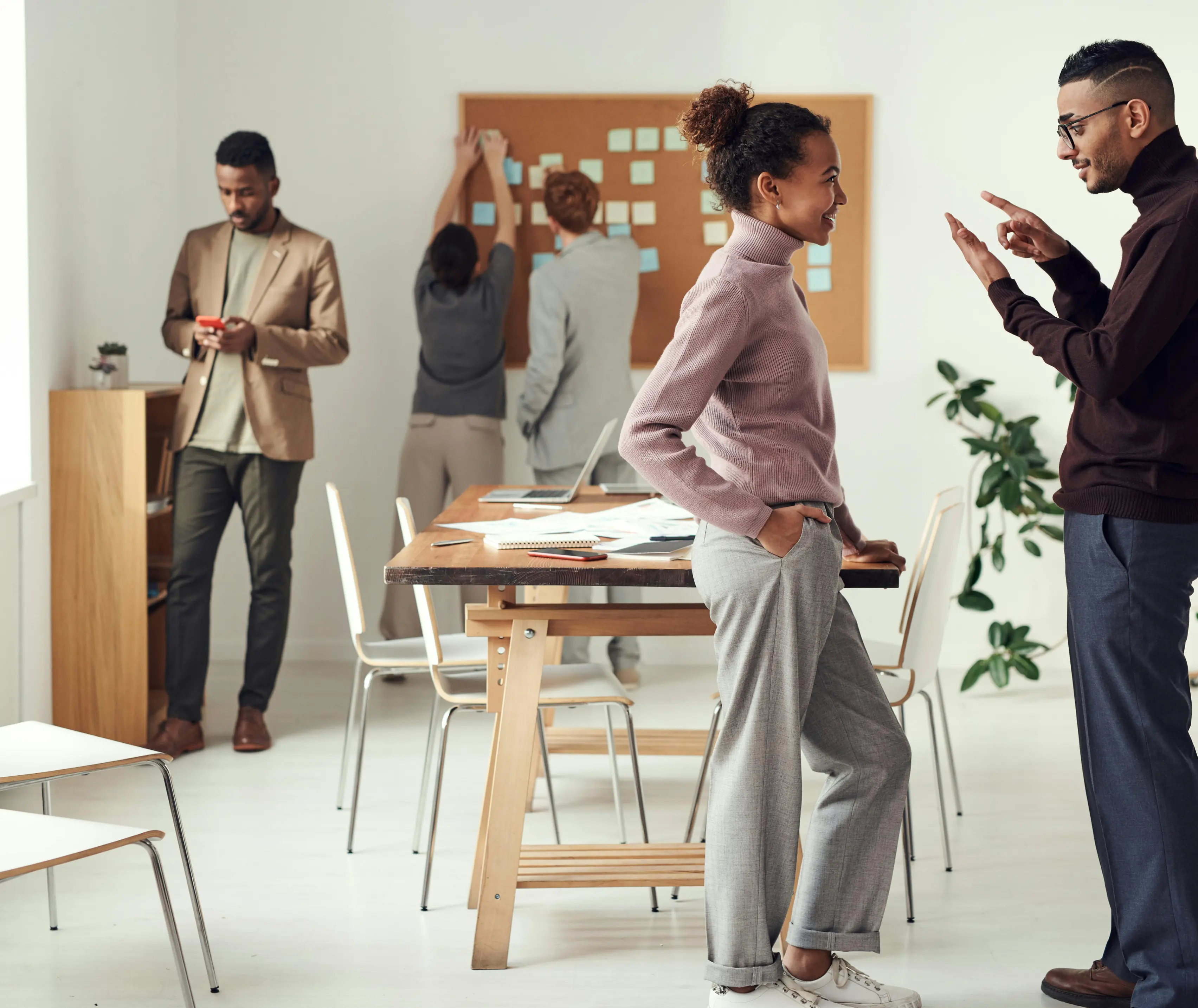 Colleagues talking together in a bright open-plan office