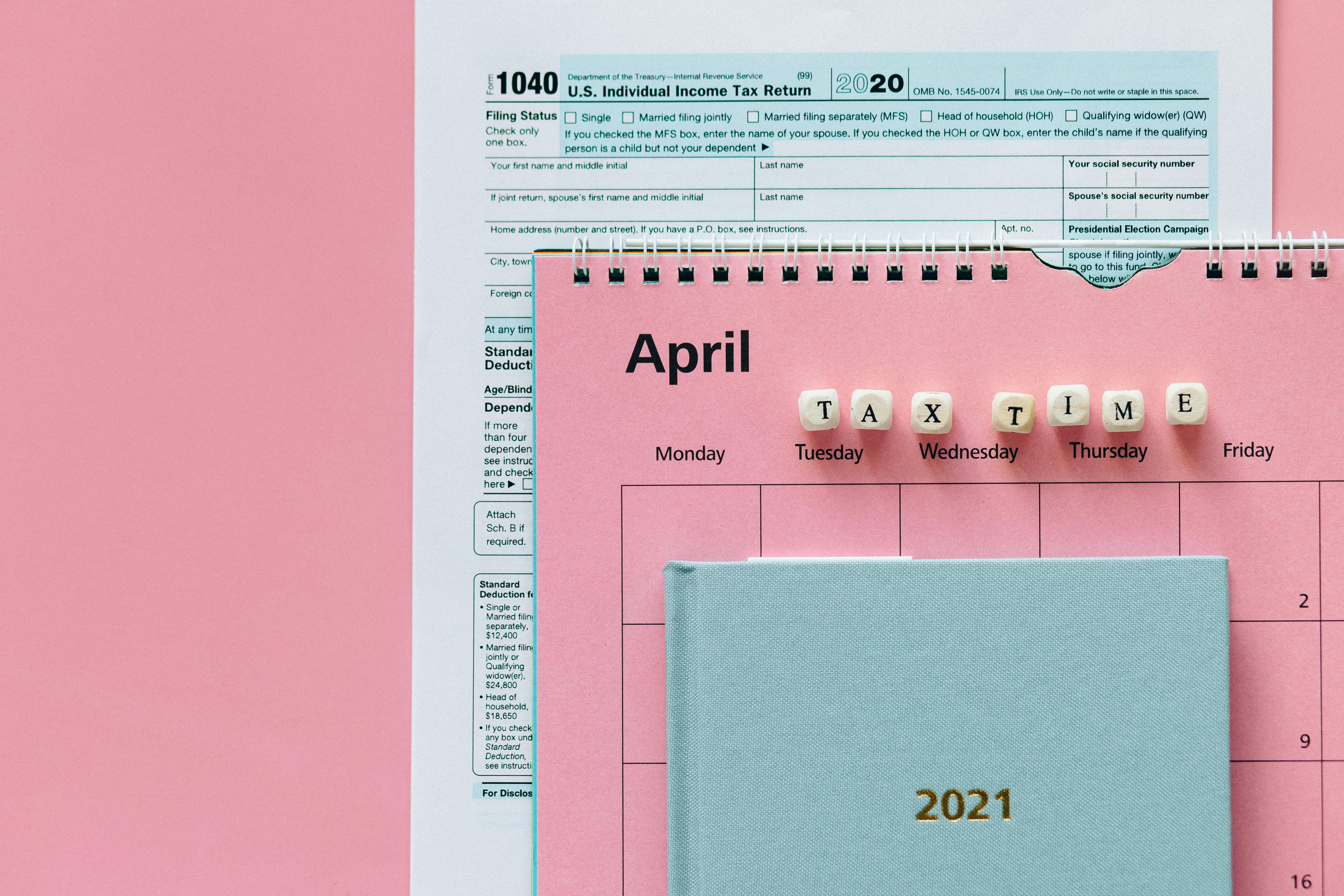 A tax return form beside an April desk calendar