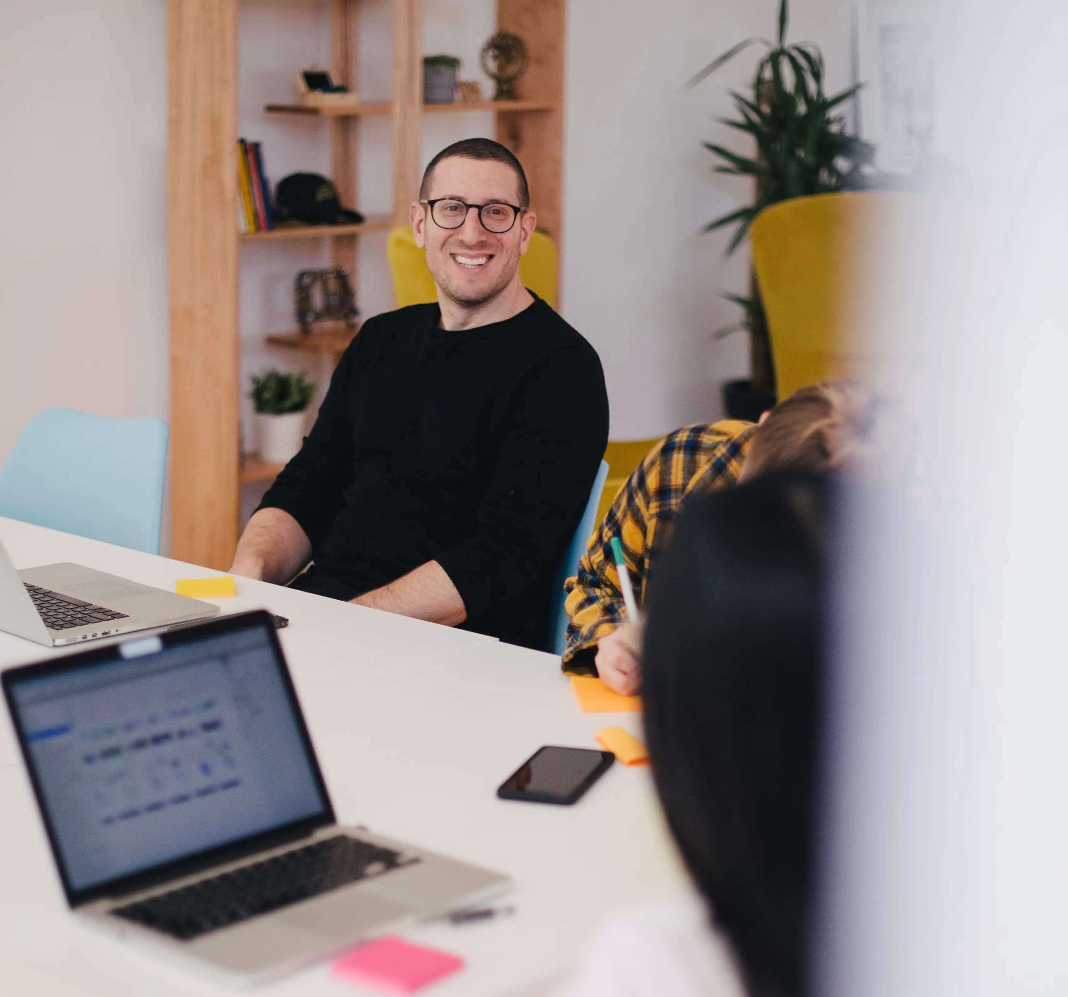 A man working at a laptop in a bright home office