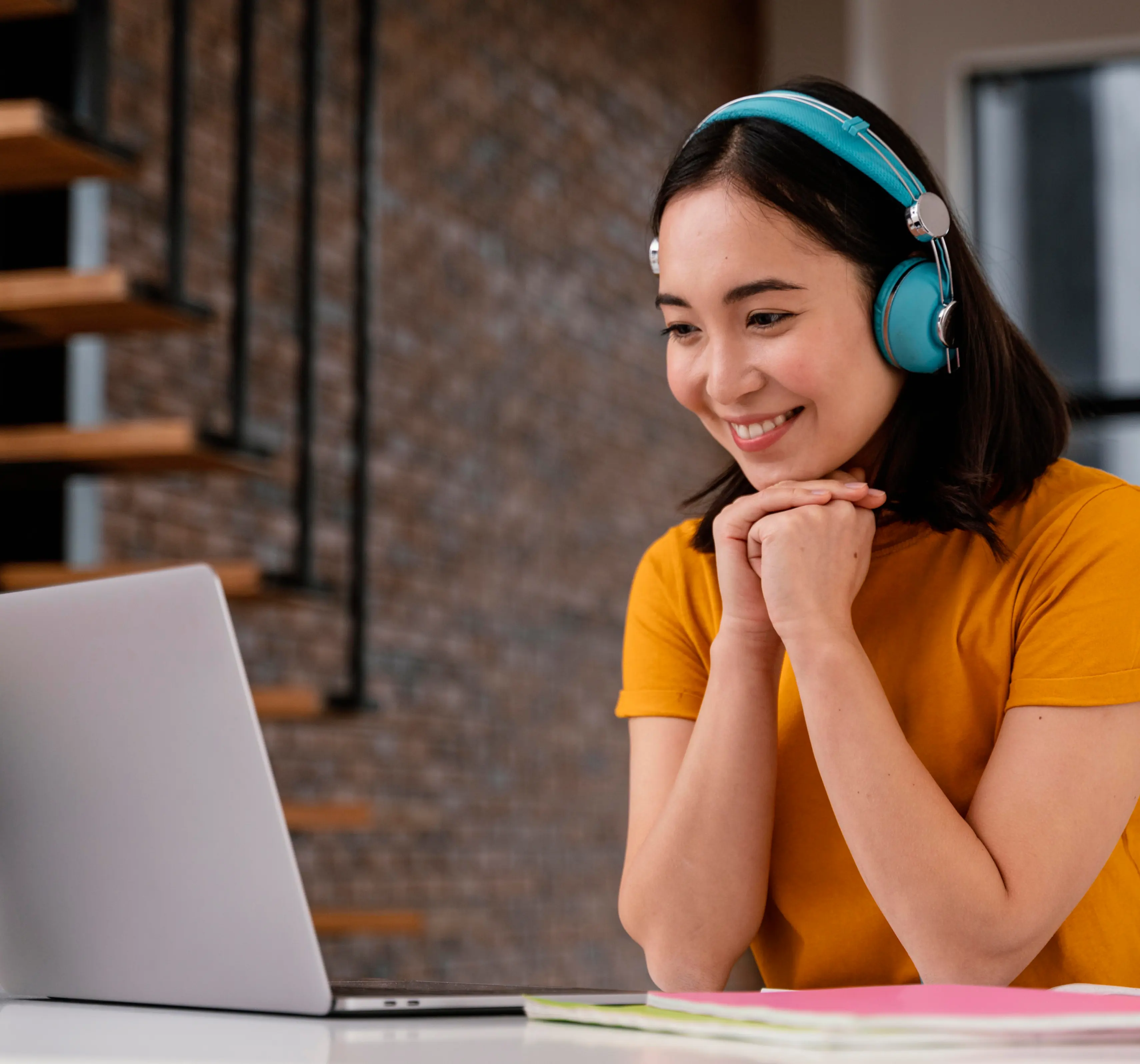 Person wearing headphones smiling at a laptop screen