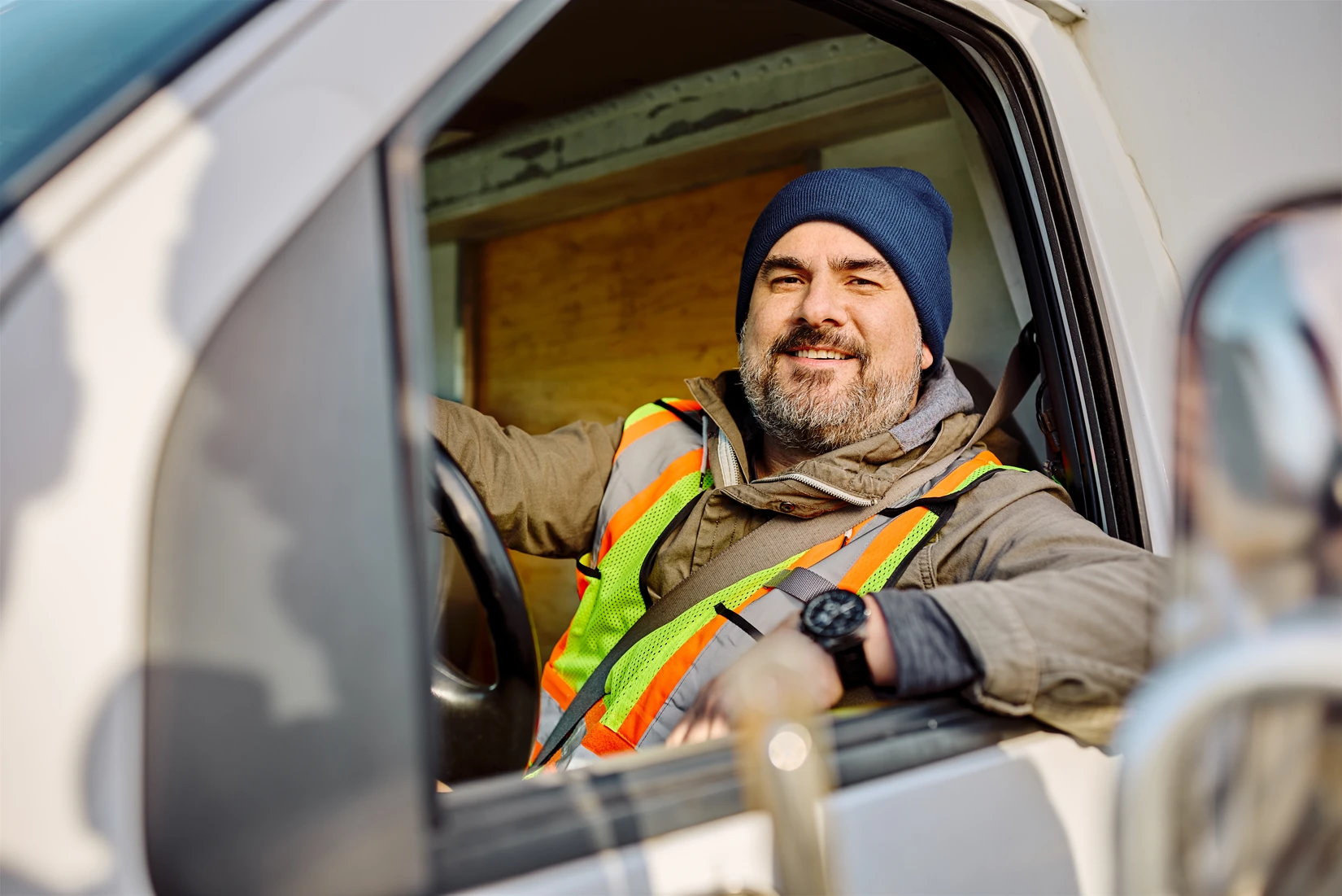 A worker in a high-visibility jacket at the wheel of a work van