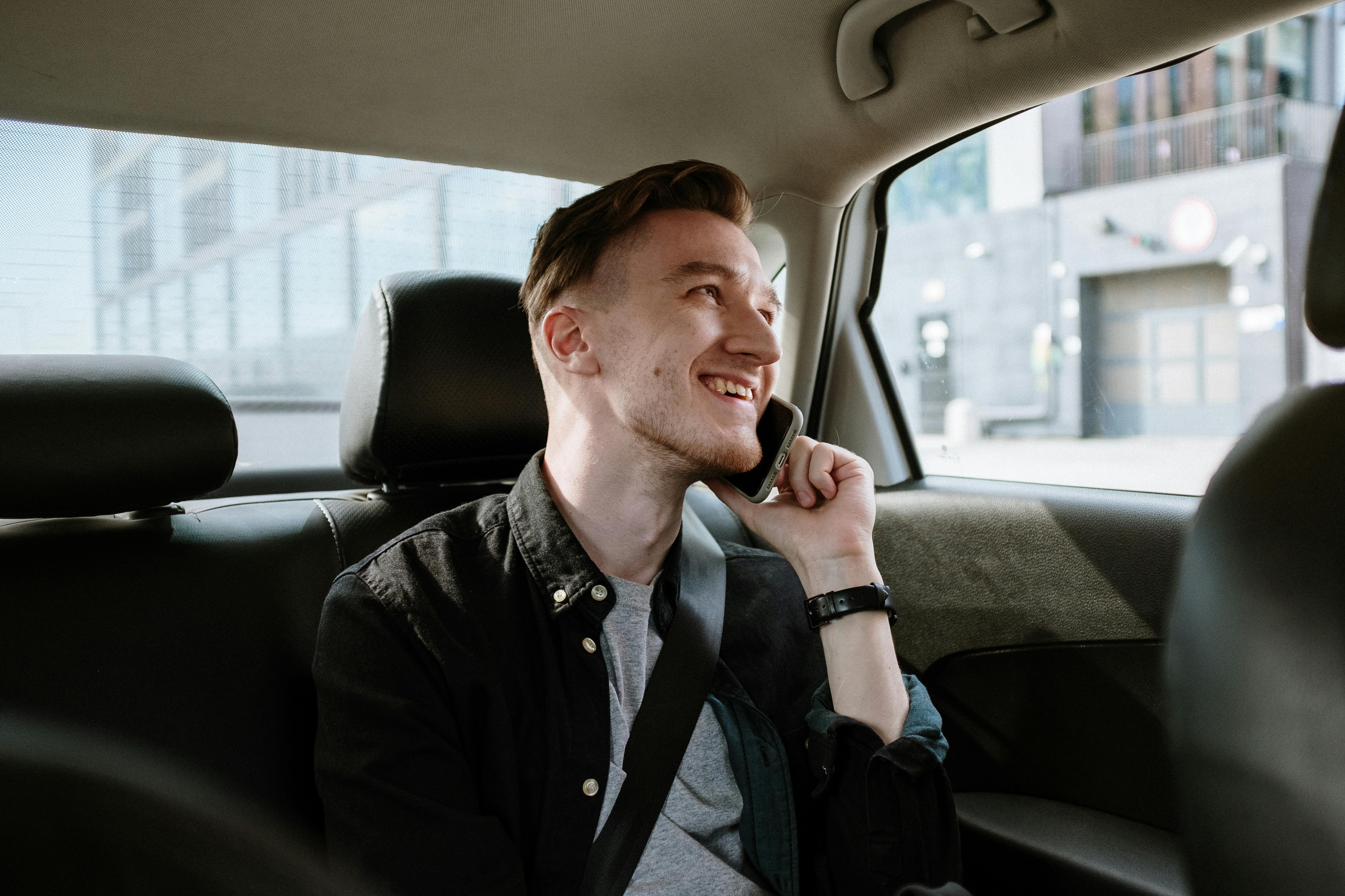 A man smiling in the front seat of a car