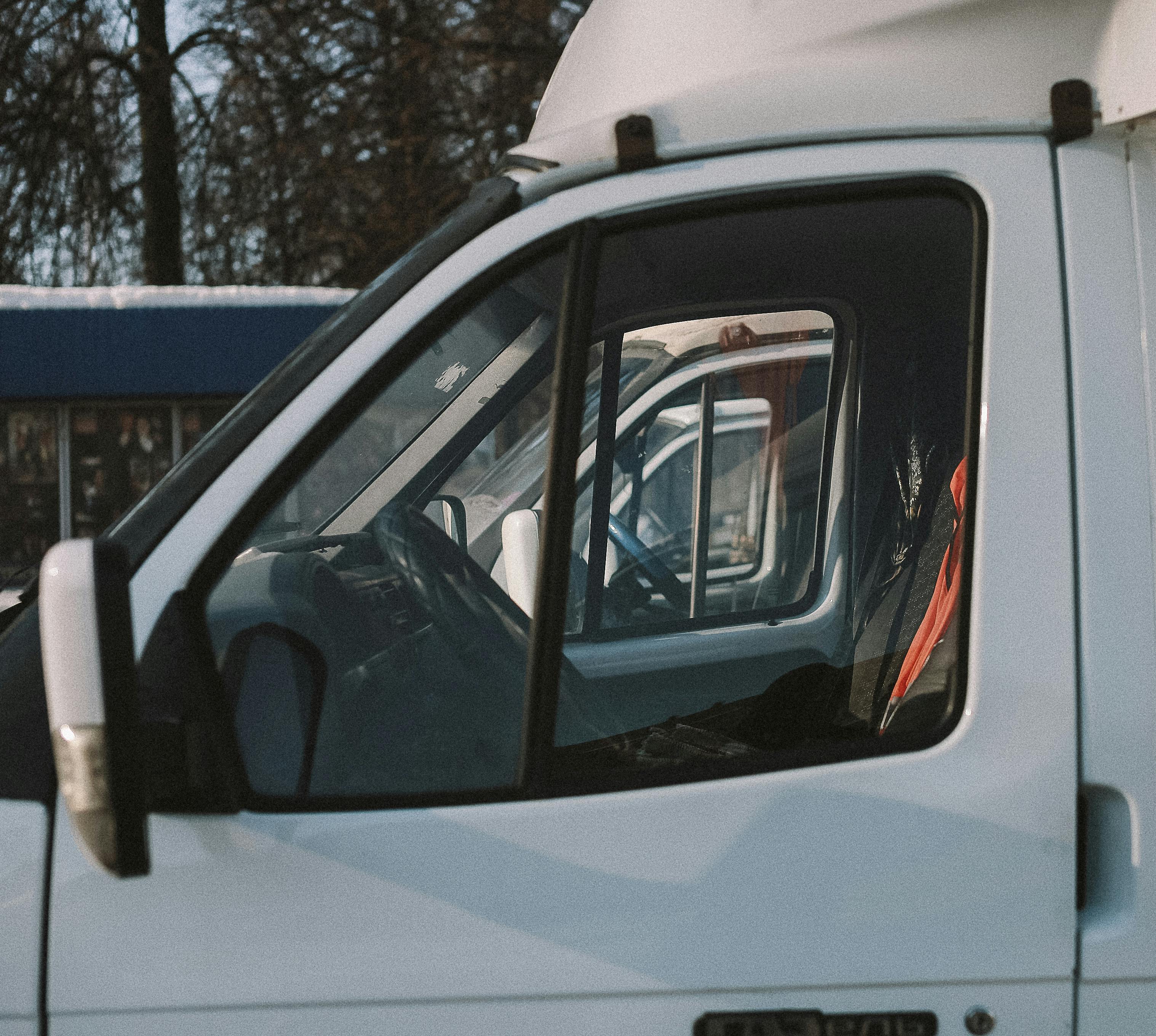 Cab of a white work van parked outside