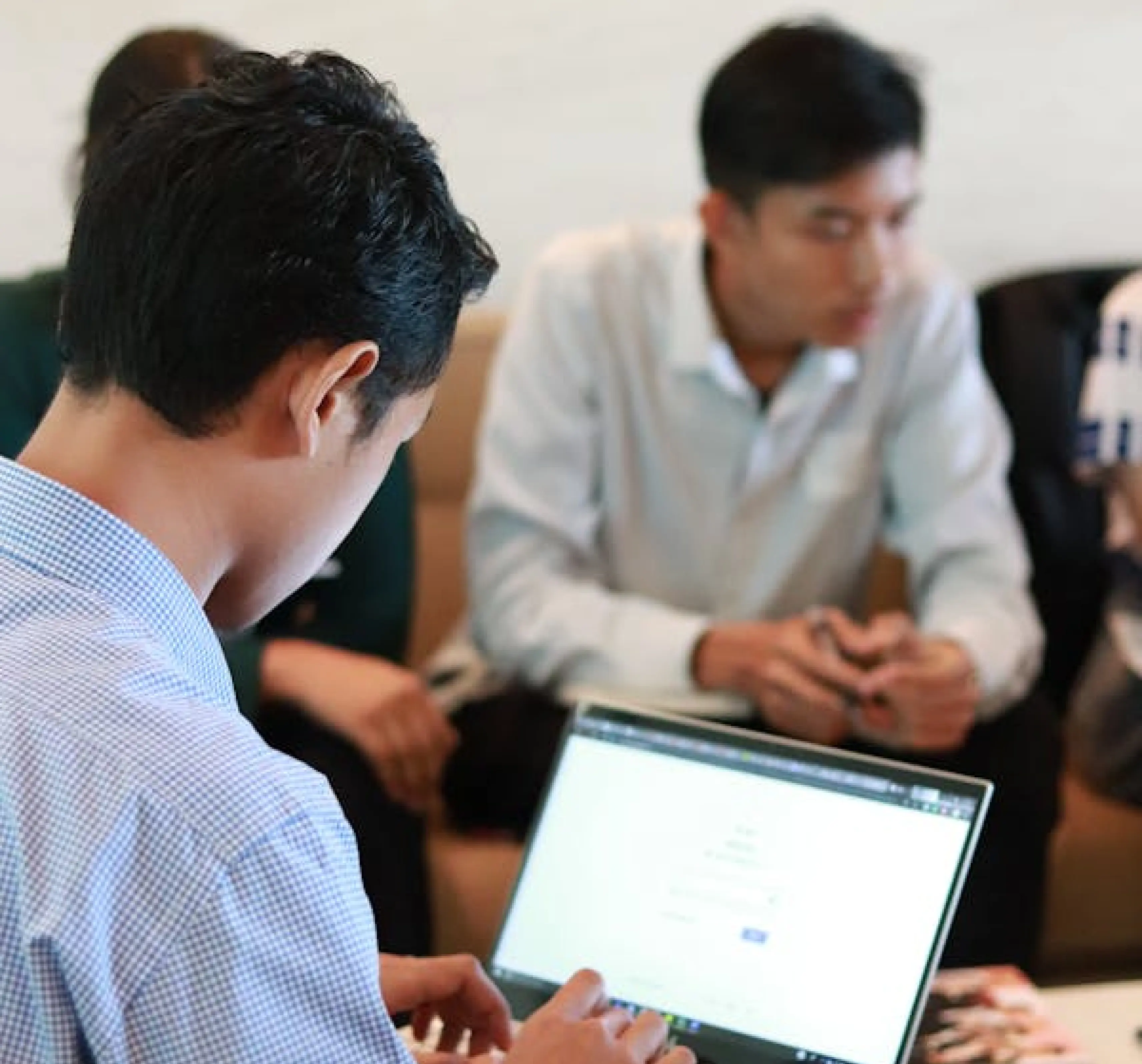 Two people going through figures together on a laptop