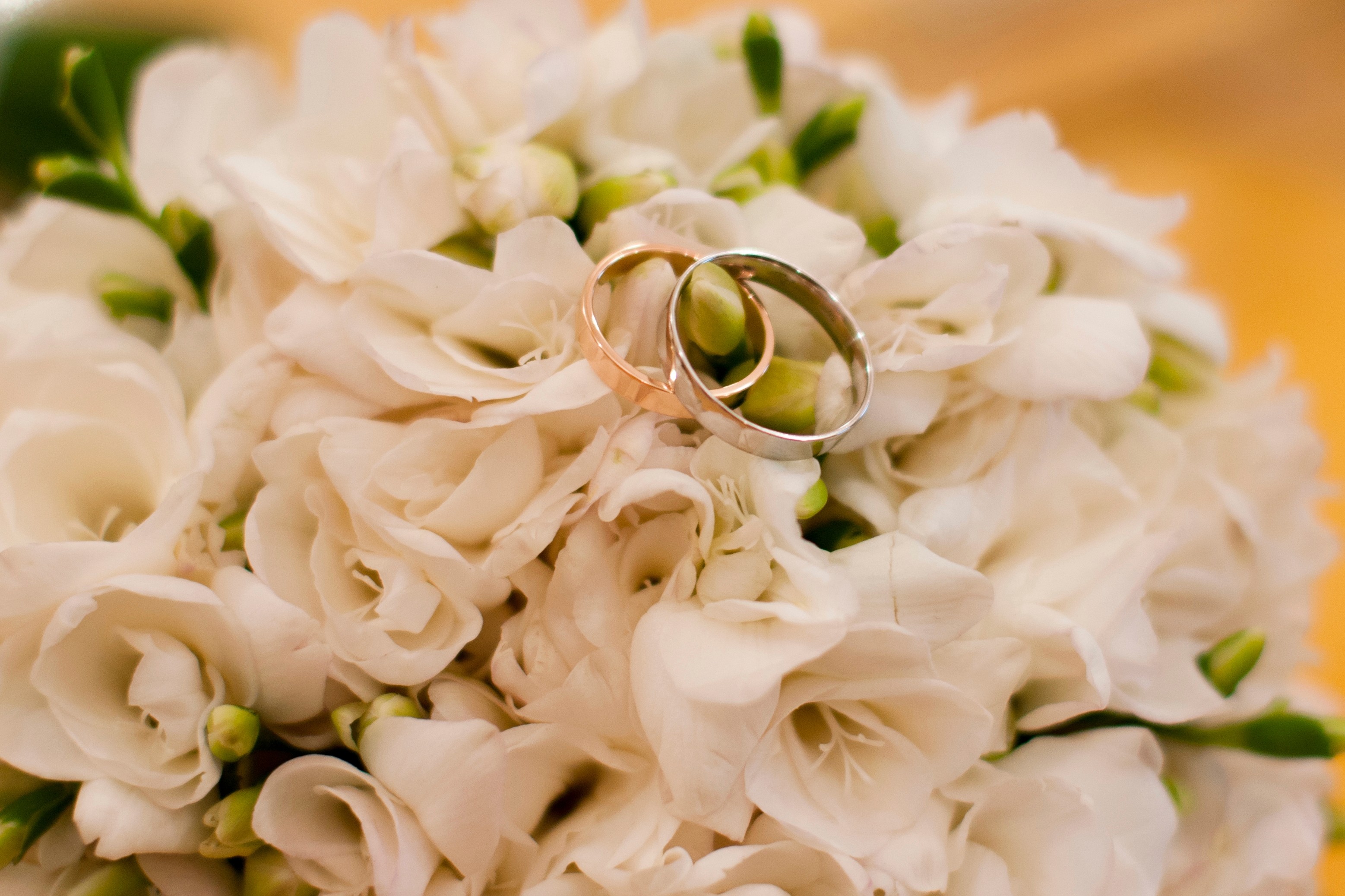 Two wedding rings resting on a bouquet