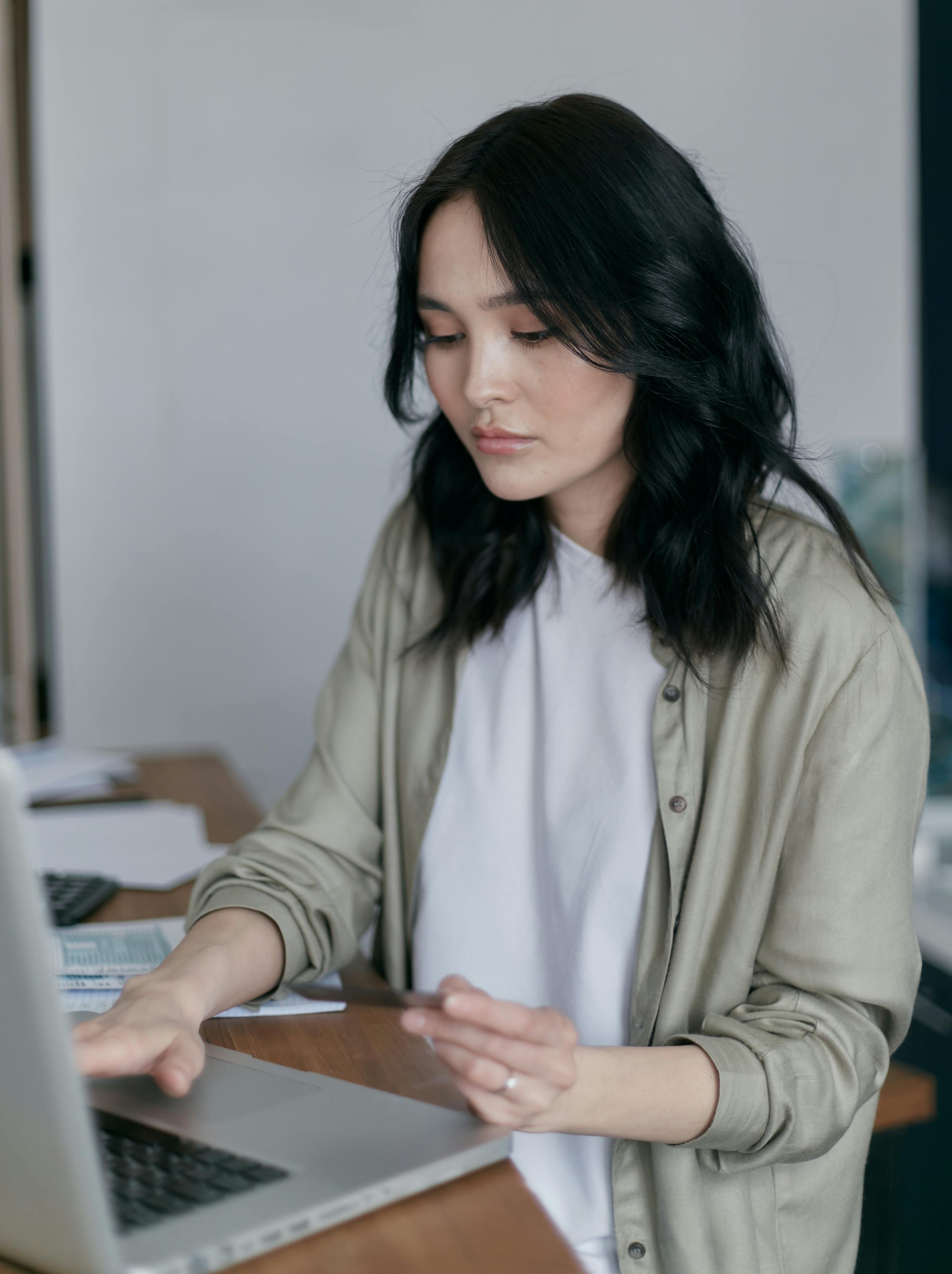A woman working through paperwork at her desk